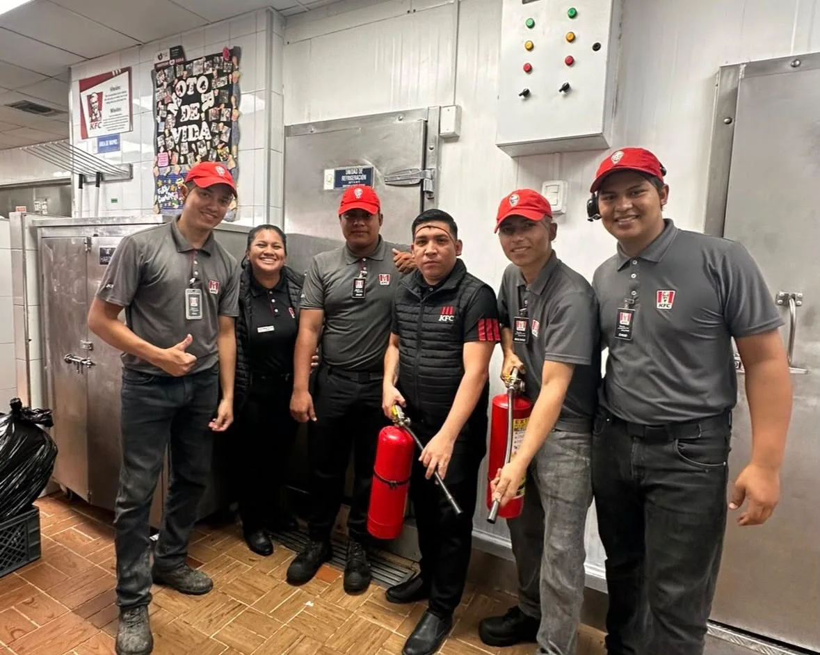 Personal KFC en capacitación con extintores