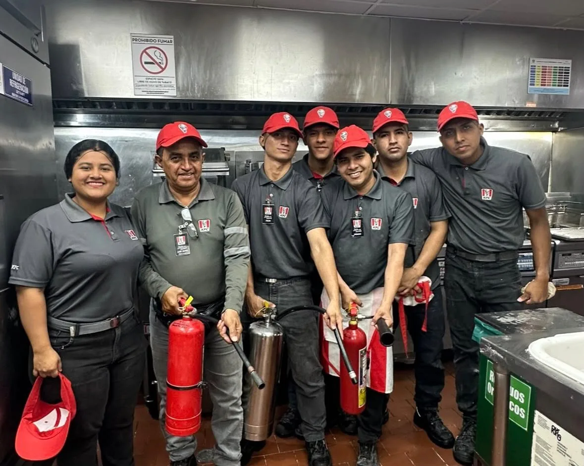 Grupo KFC en cocina con extintores para capacitación