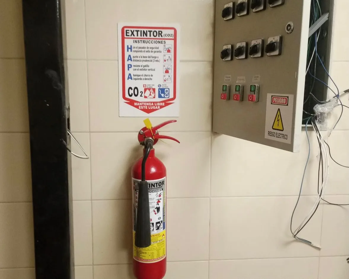 Extintor portátil instalado junto a panel eléctrico