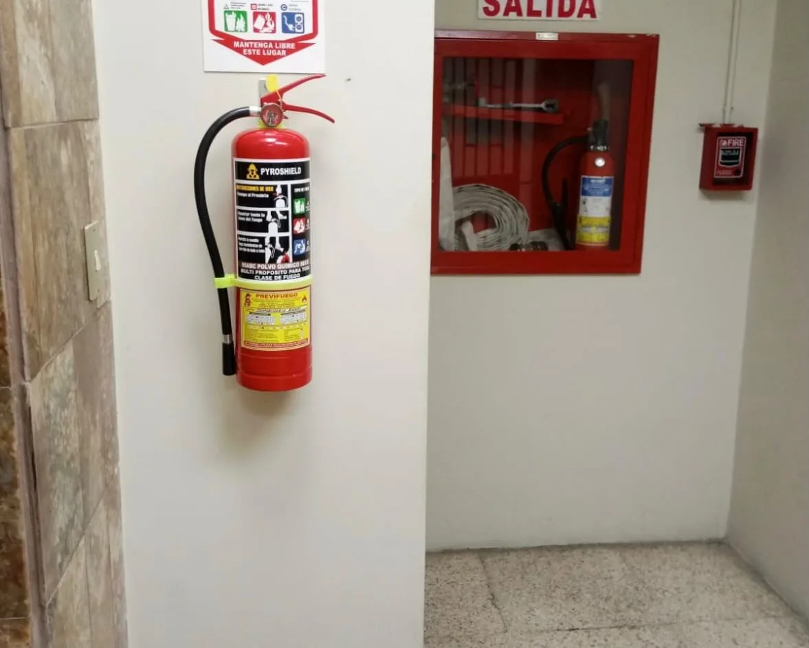 Extintor en pasillo con gabinete CI y señalética