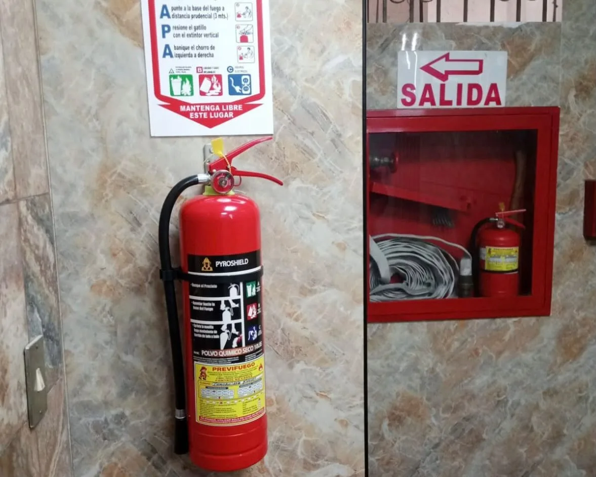 Extintor PQS en restaurante con gabinete de manguera