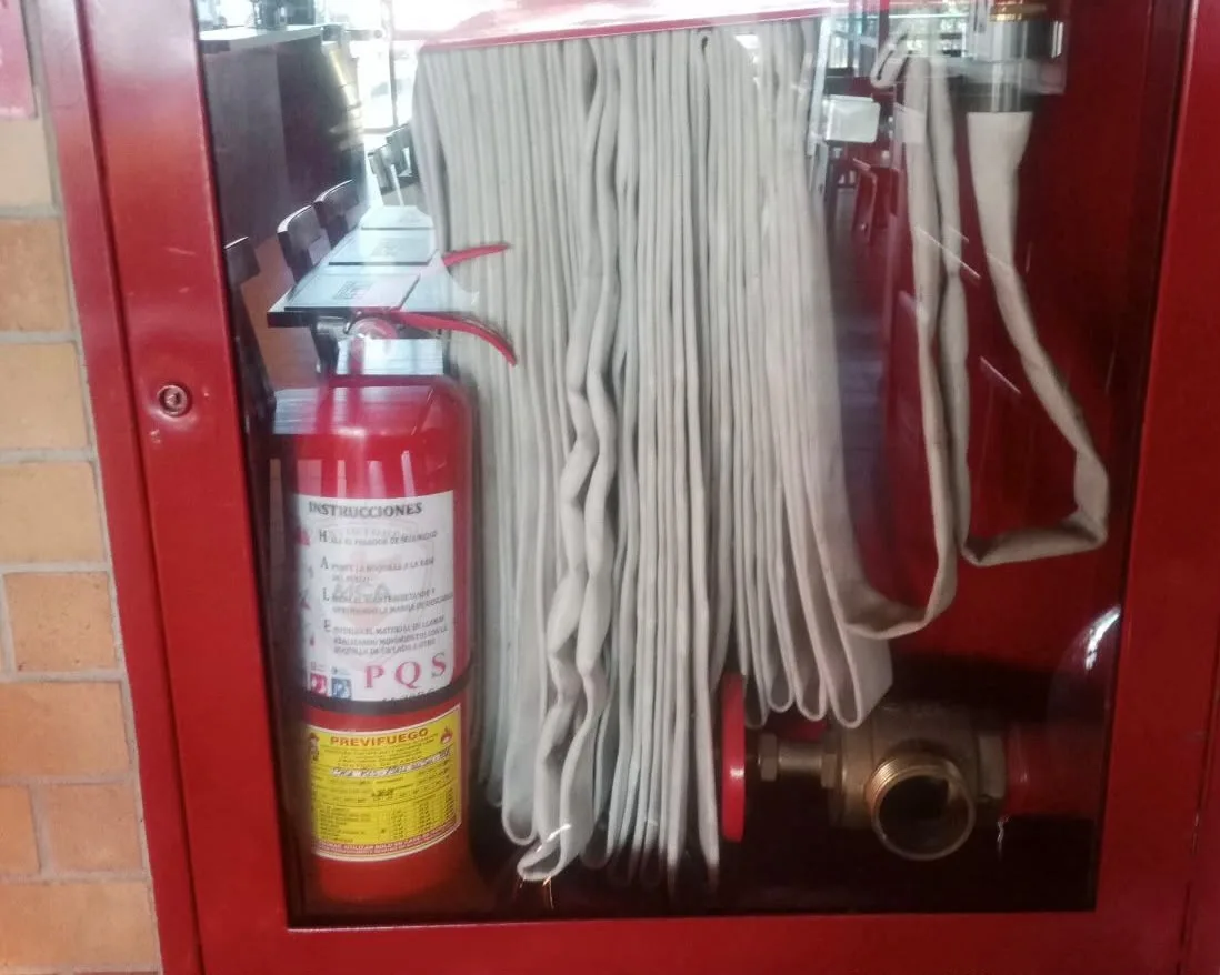 Extintor PQS y manguera en gabinete CI rojo