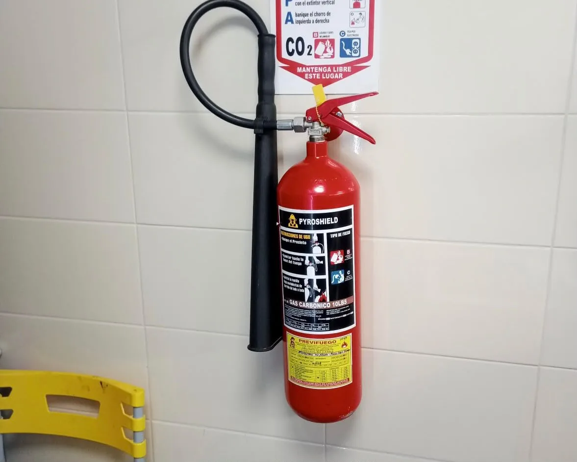 Extintor CO₂ Pyroshield instalado con señalética en área de cocina